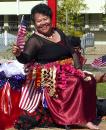 A smiling Tongan lady in the parade with US flags